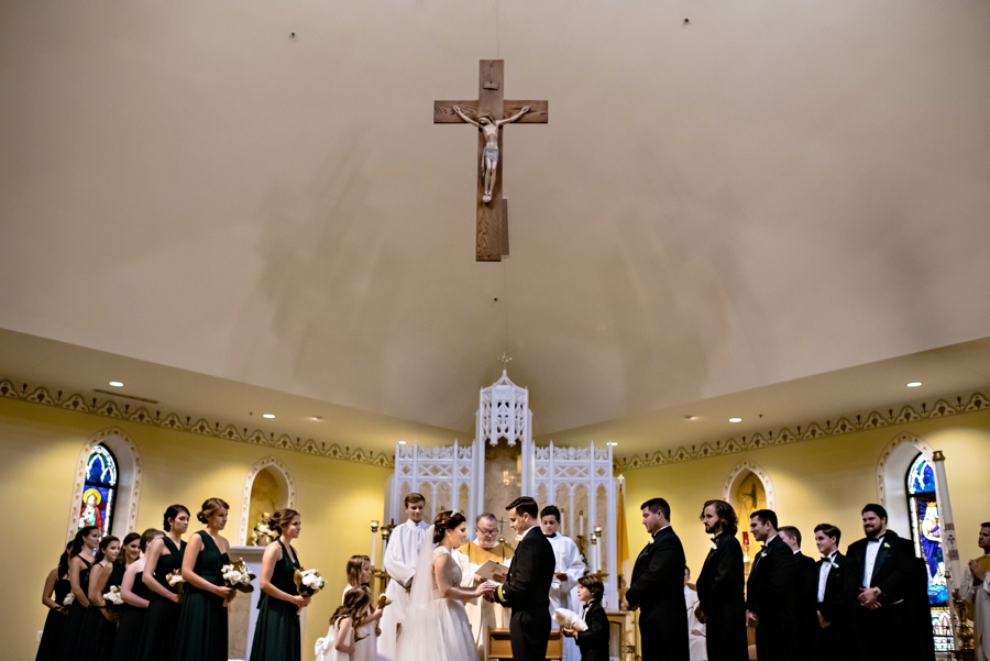 A wedding party stand at the alter during a catholic wedding in Philadelphia.